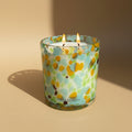 Colorful glass candle holder with floral pattern on a light background