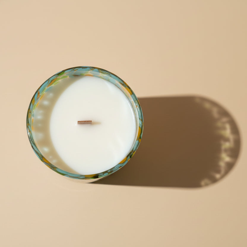 Candle in a glass container on a beige background