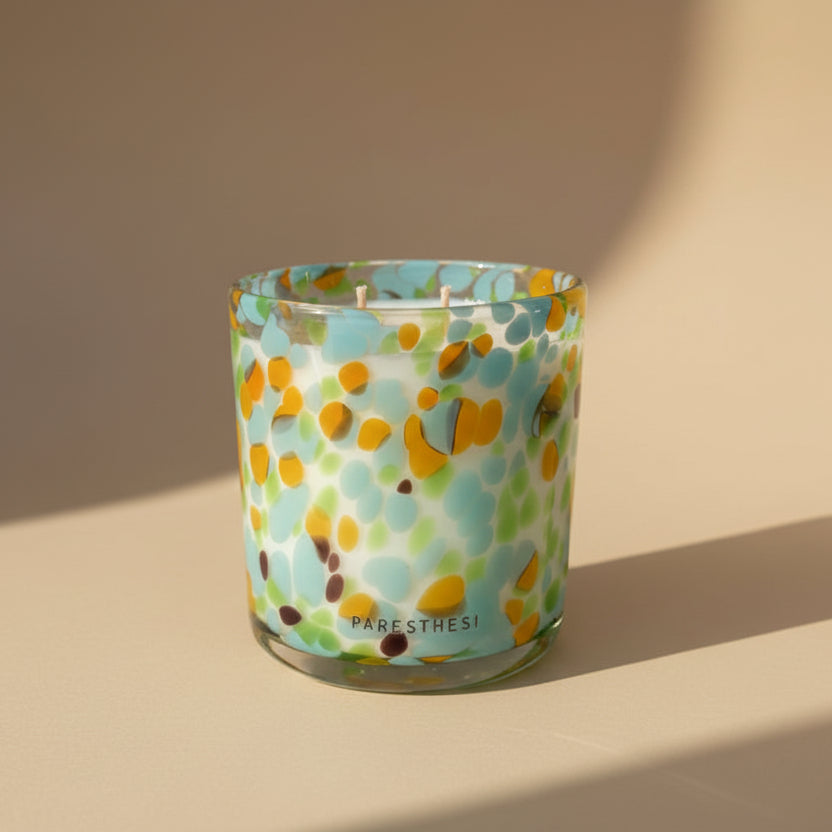 Colorful candle with a pattern on a beige background