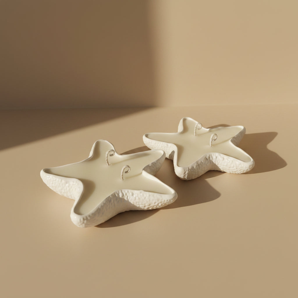 Two star-shaped porcelain trays filled with a candle on a beige background