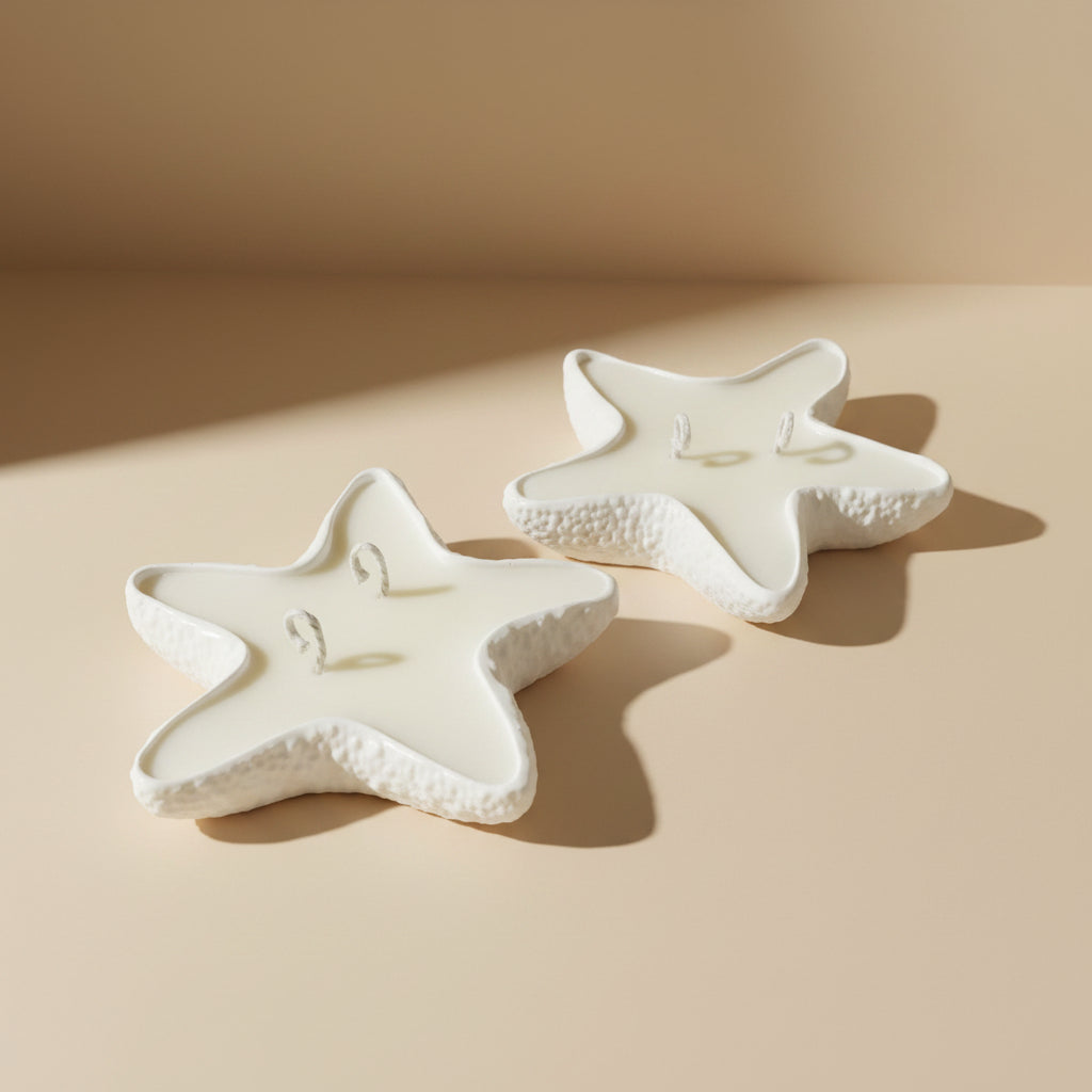Two star-shaped porcelain trays filled with a candle on a beige background