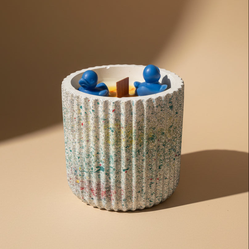 Candle with decorative ducks on beige background