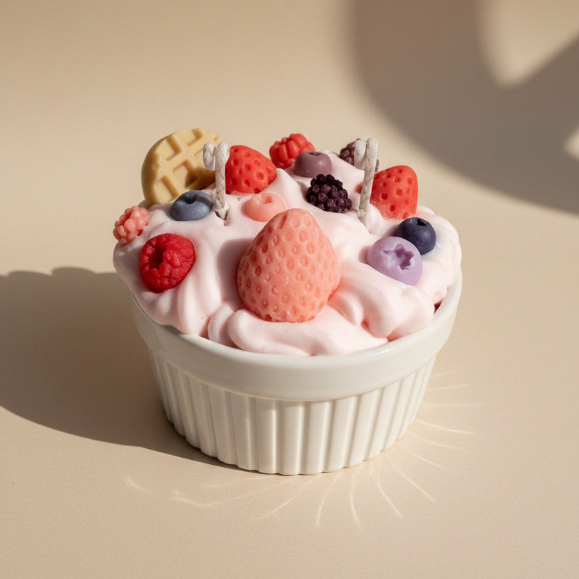 White cup filled with pink whipped cream, berries, and cookies candle on a white background