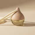Car diffuser with a drop shape vessel with a string on a plain background