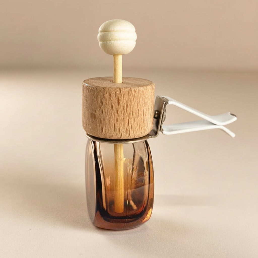 Car diffuser in an amber glass bottle with wooden cap on a beige background