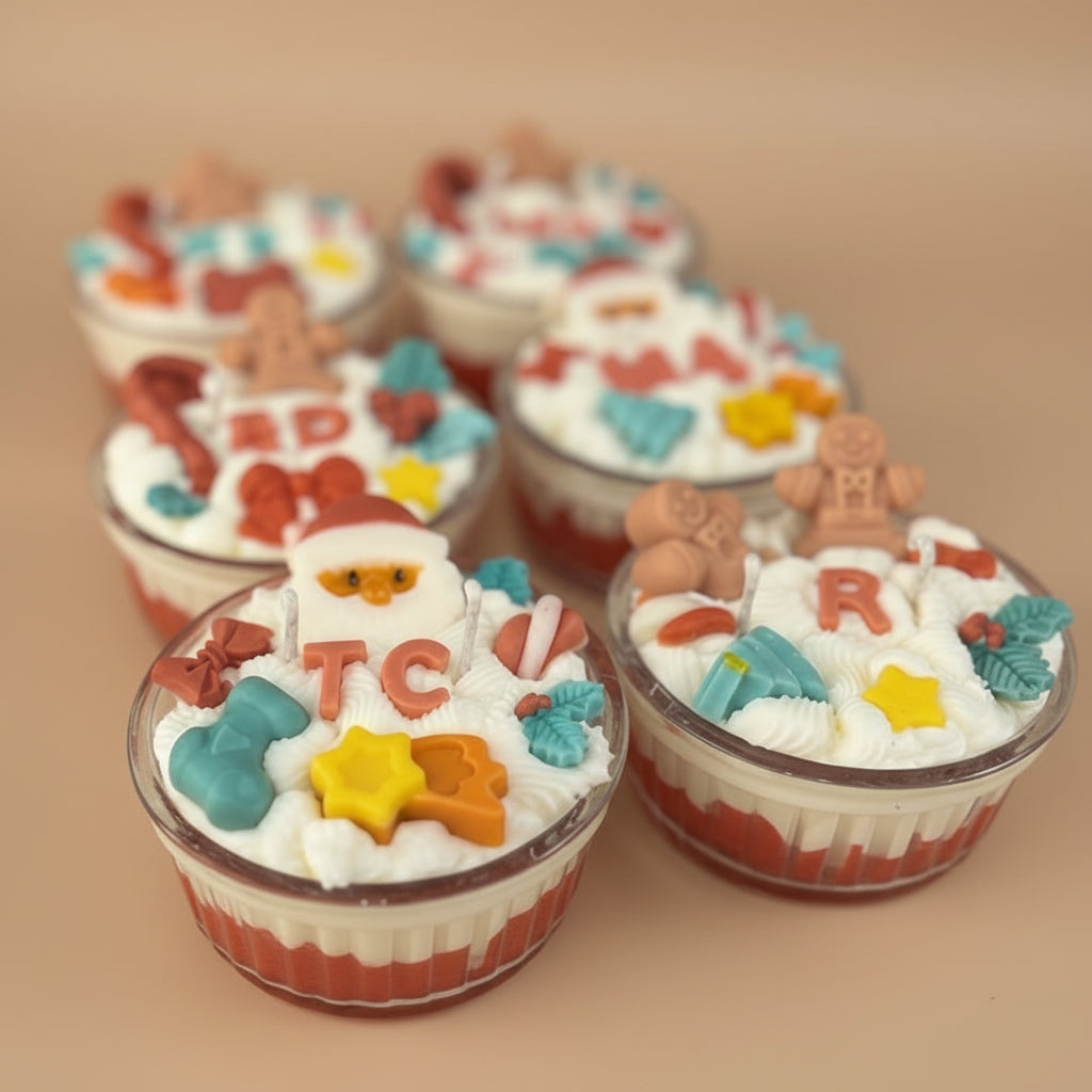 Decorative candle cupcake with colorful wax letters and shapes on a white surface.