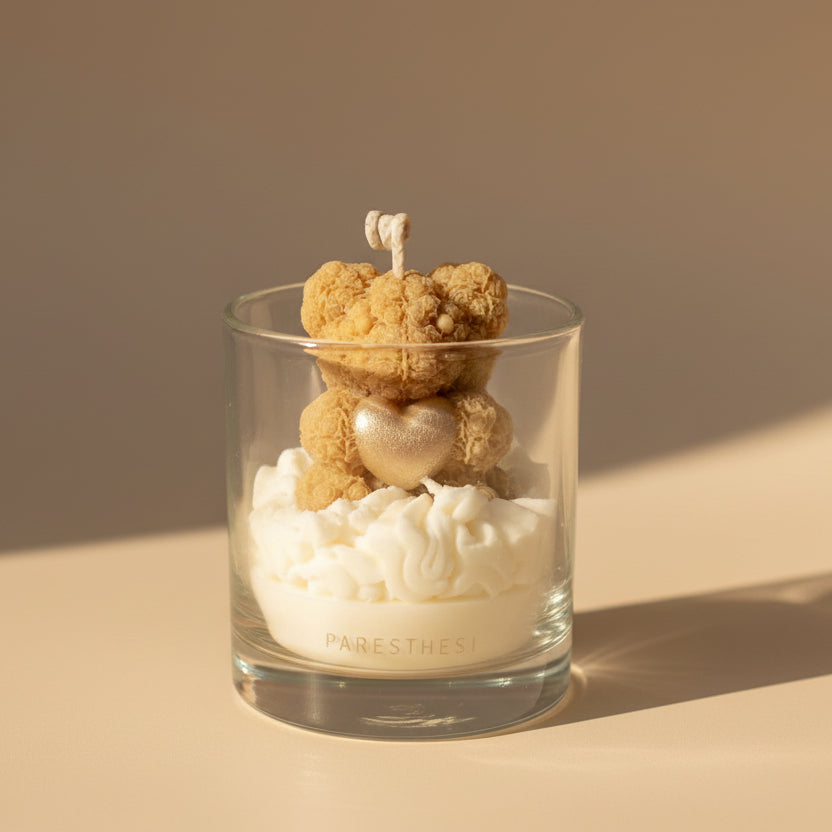 Candle in a glass jar with a bear-shaped wick on a beige background