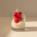 Candle shaped like a teddy bear in a glass container on a neutral background