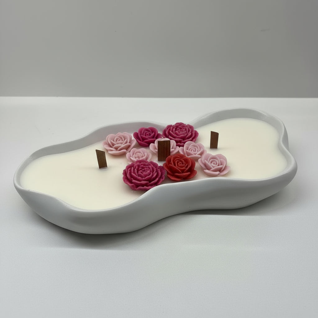 Decorative candle with red, pink flowers on a white surface