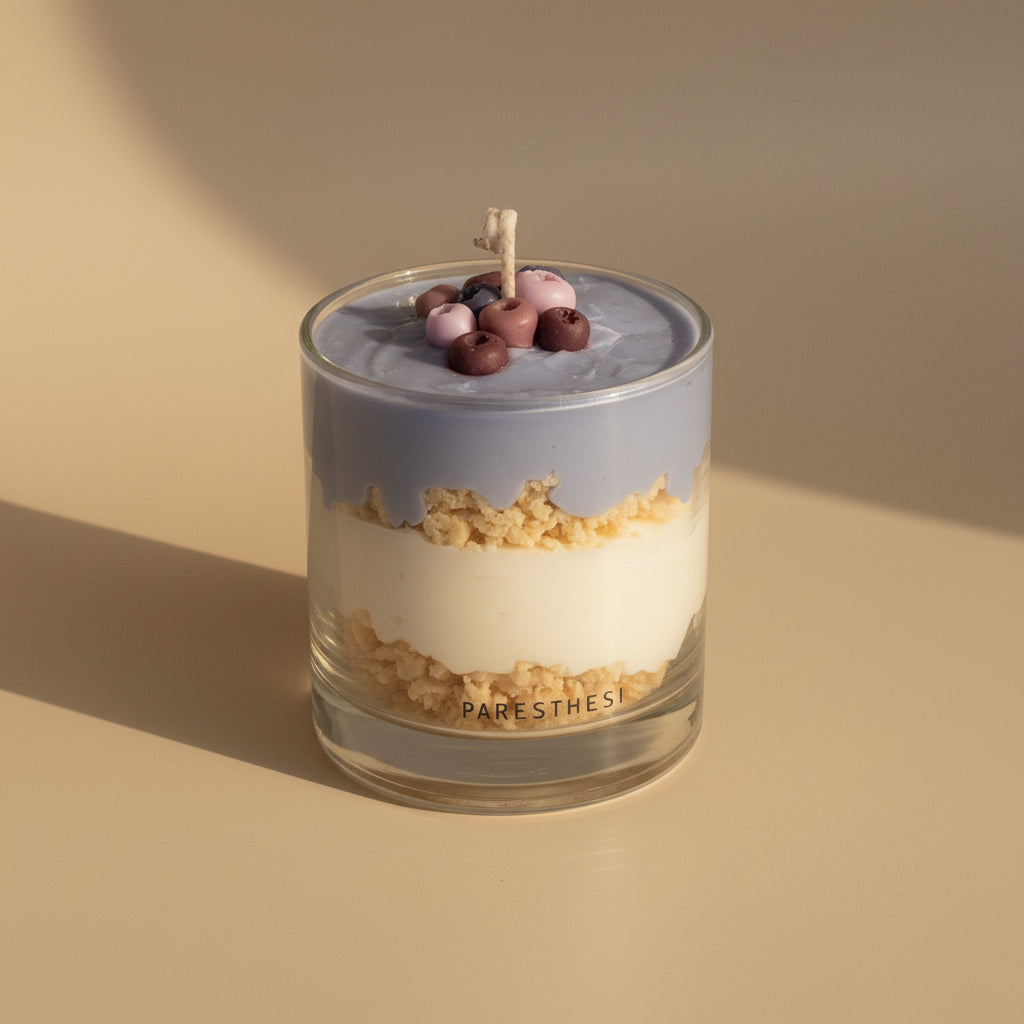 Glass dessert candle with layered textures and berries on a beige background