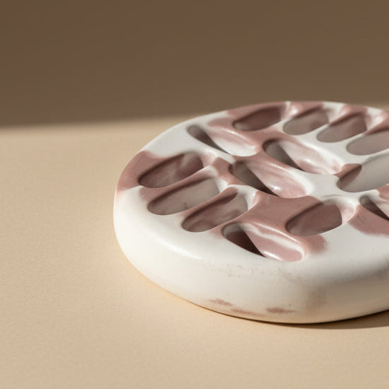 Porcelain jewelry tray with a marbled design on a beige background