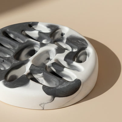 Porcelain jewelry tray with a marbled design on a beige background