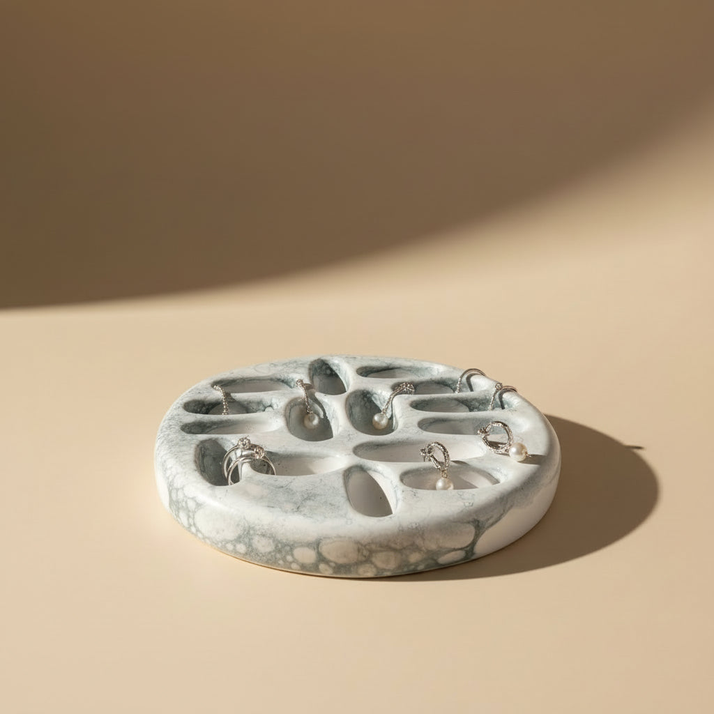 Porcelain jewelry tray with a marbled design on a beige background