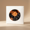 A white square gift box with a circular cutout window showing Halloween-themed wax melt shapes, set against a warm beige background.