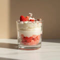 Glass container with candle cream and strawberries on a beige background