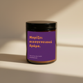 A jar of natural soy wax candle by the brand Paresthesi, featuring a purple label with Greek text and a black lid, set against a plain beige background.