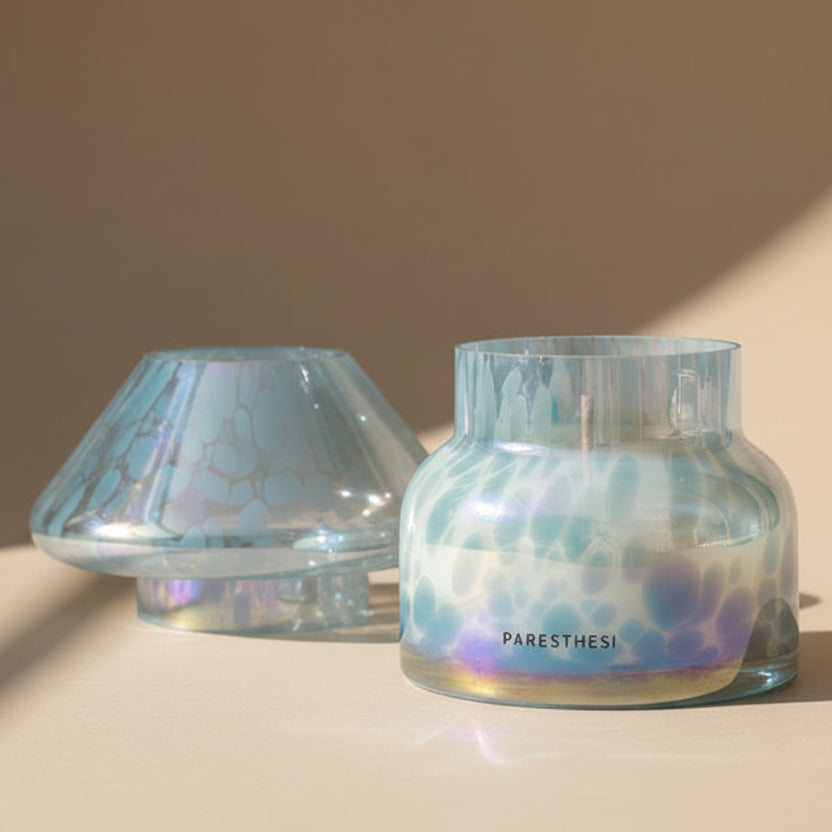 Lamp candle in lagoon color with an iridescent finish on a beige background