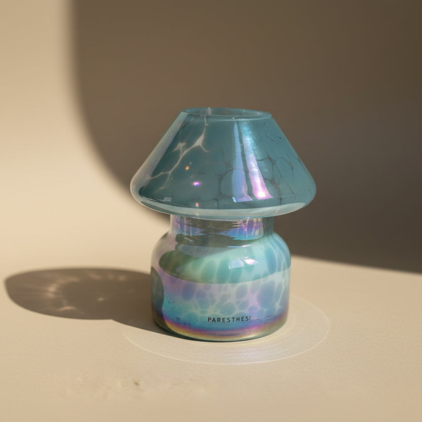 Light Blue Glass jar  with a candle and with a dots pattern on a neutral background