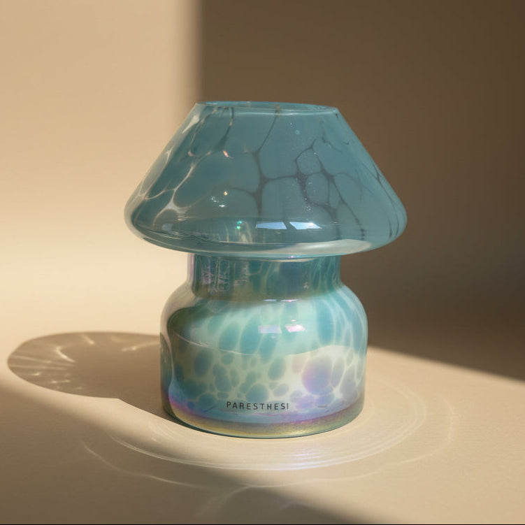 Light Blue Glass jar  with a candle and with a dots pattern on a neutral background
