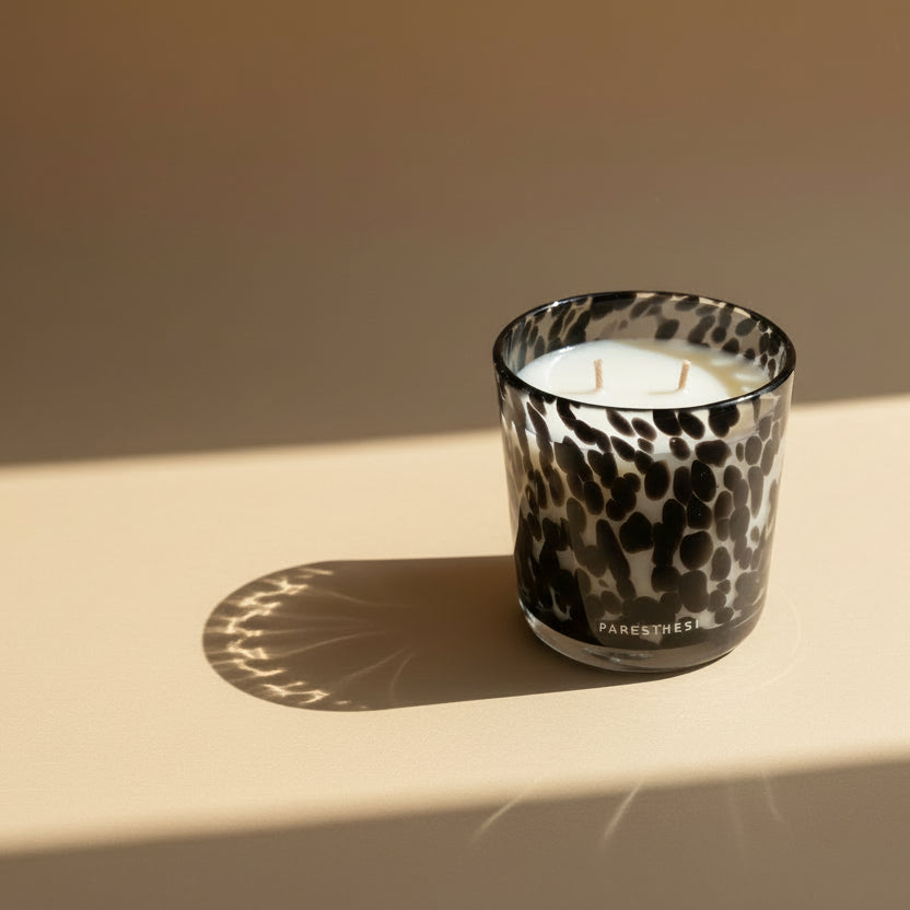 Leopard print candle holder with a white candle inside on a light beige surface.