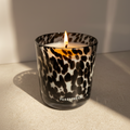 Candle in a leopard print container on a neutral surface