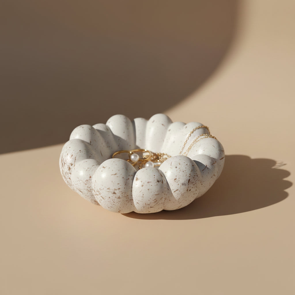 White textured jewelry dish with rings on a beige background