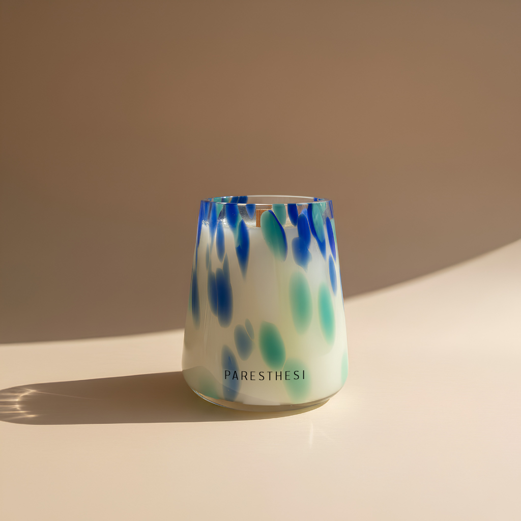 Glass with blue and green abstract pattern on a beige background