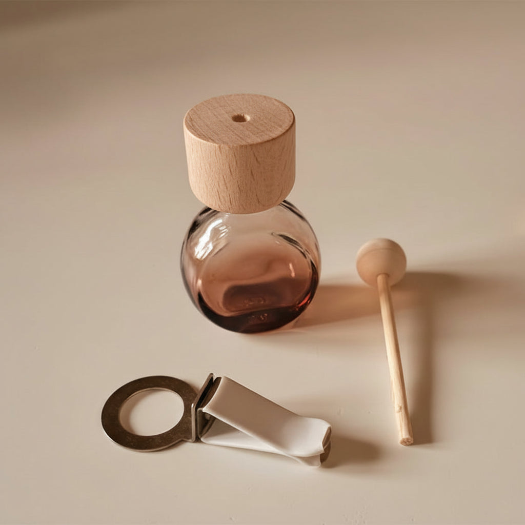 Car diffuser in an amber glass bottle with wooden cap on a beige background