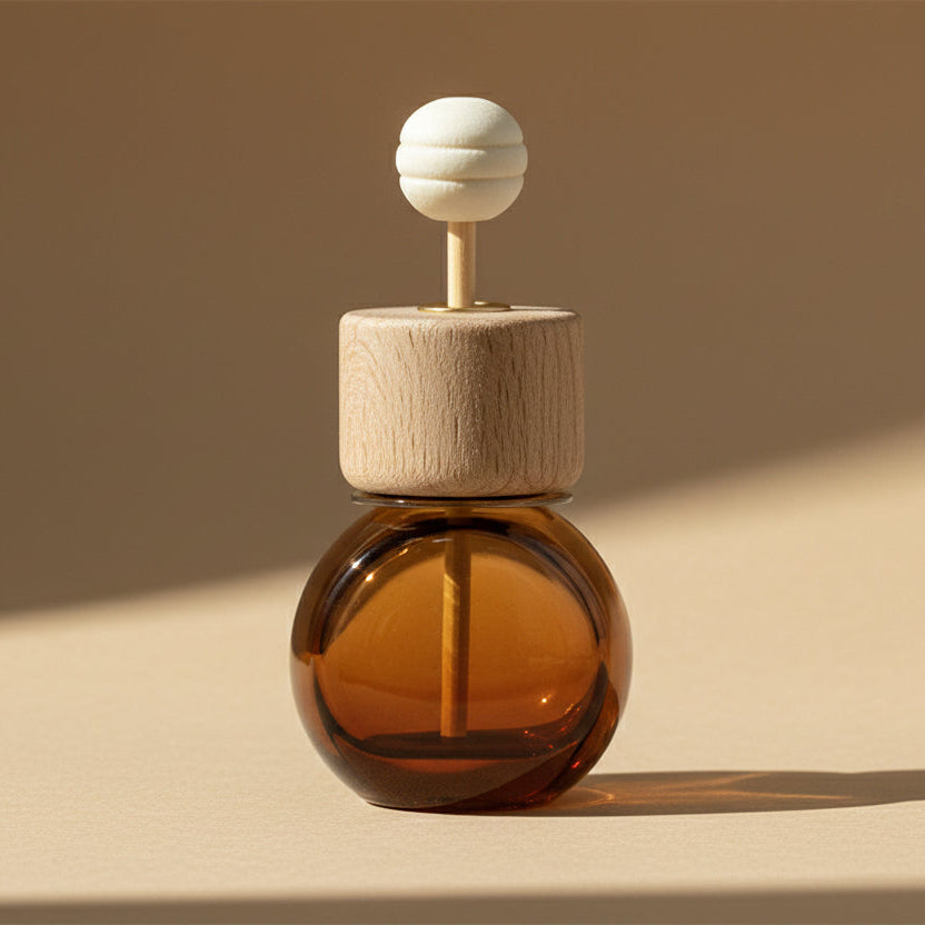 Car diffuser in an amber glass bottle with wooden cap on a beige background