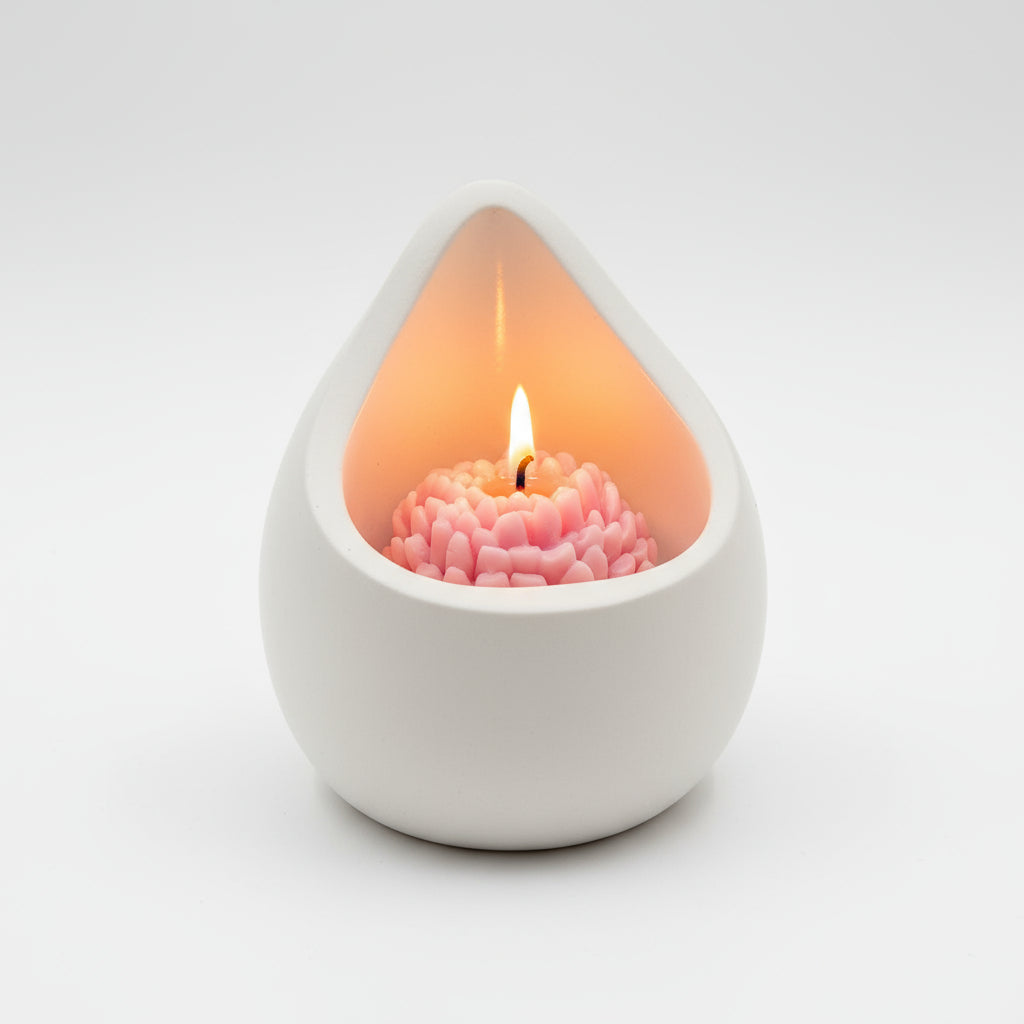Teardrop-shaped candle holder with a pink candle on a white background