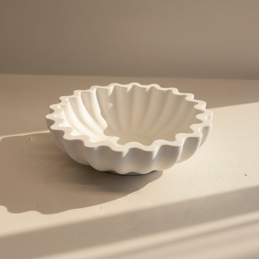 White porcelain bowl with textured design on a beige surface