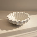 White porcelain bowl with textured design on a beige surface