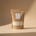 Container of Moonlit Jasmine Sand Wax with a label on a shelf.
