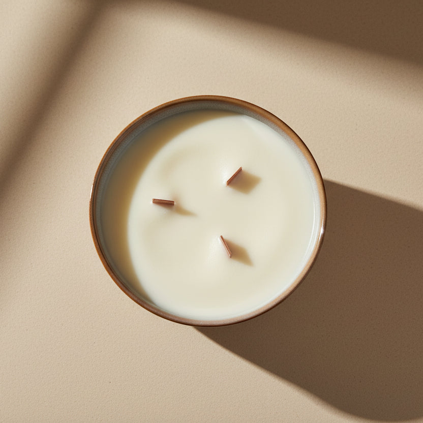 Candle in a round container with a wooden wick on a beige background