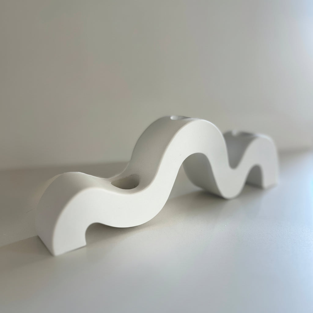 White wavy porcelain candlestick holder  on a light gray background