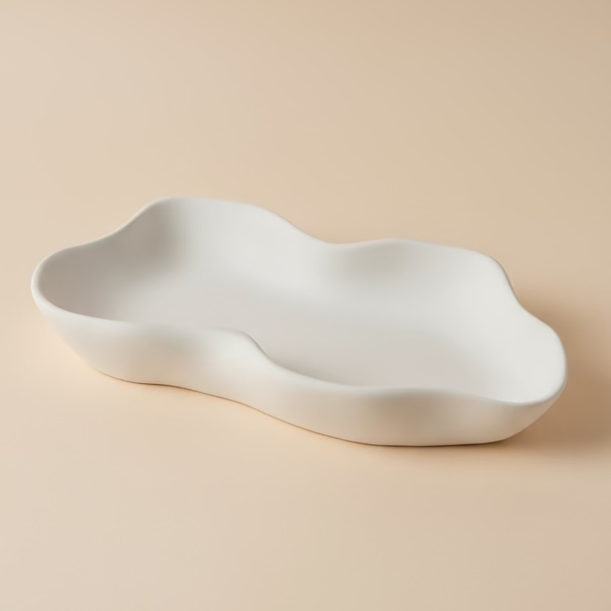 White ceramic bowl with wavy design on a beige background
