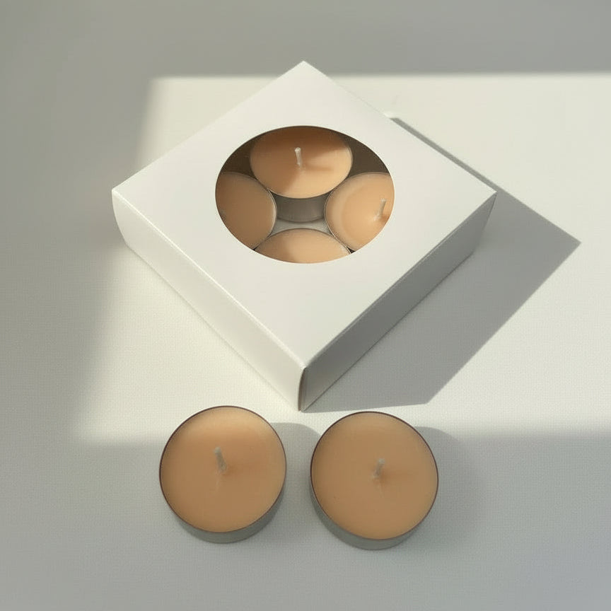Two candles in front of a white box containing four candles on a light gray background