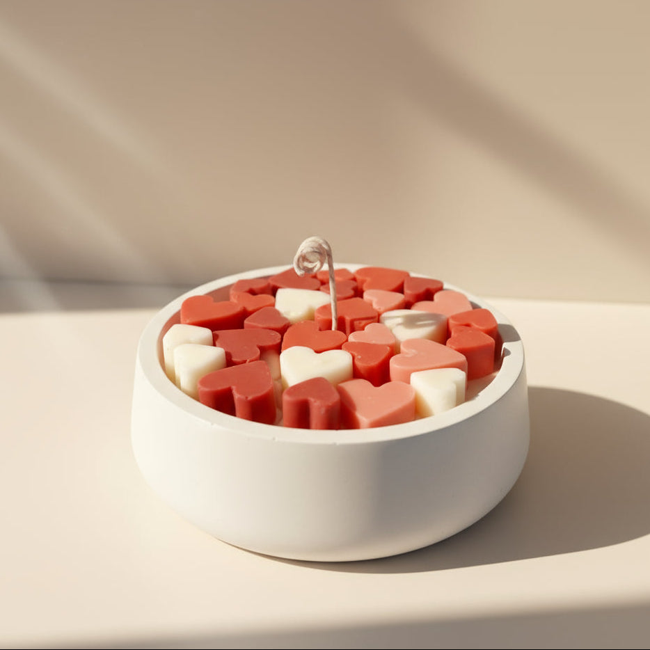 Heart-shaped candy in a white dish on a light background